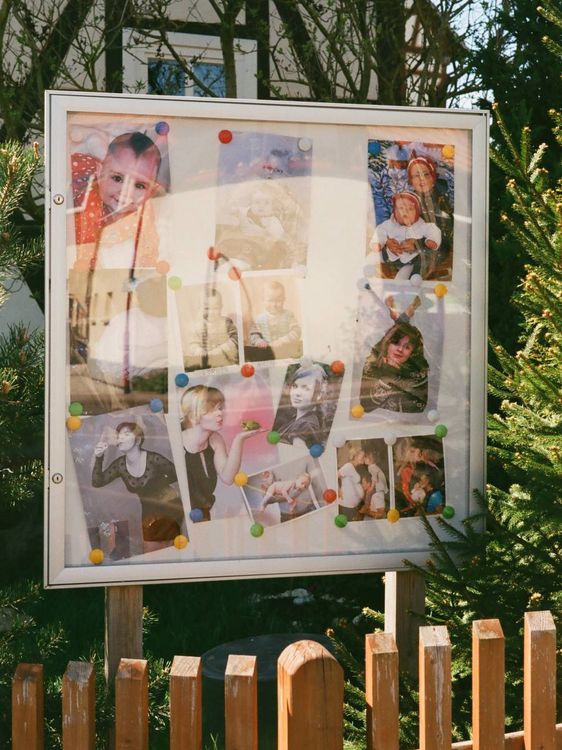 Schaukasten mit Fotos von Kindern und Erwachsenen.