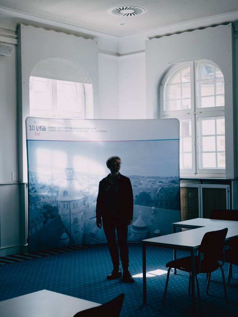 Brigitte Finke steht in einem abgedunkelten Konferenzraum des Institus.