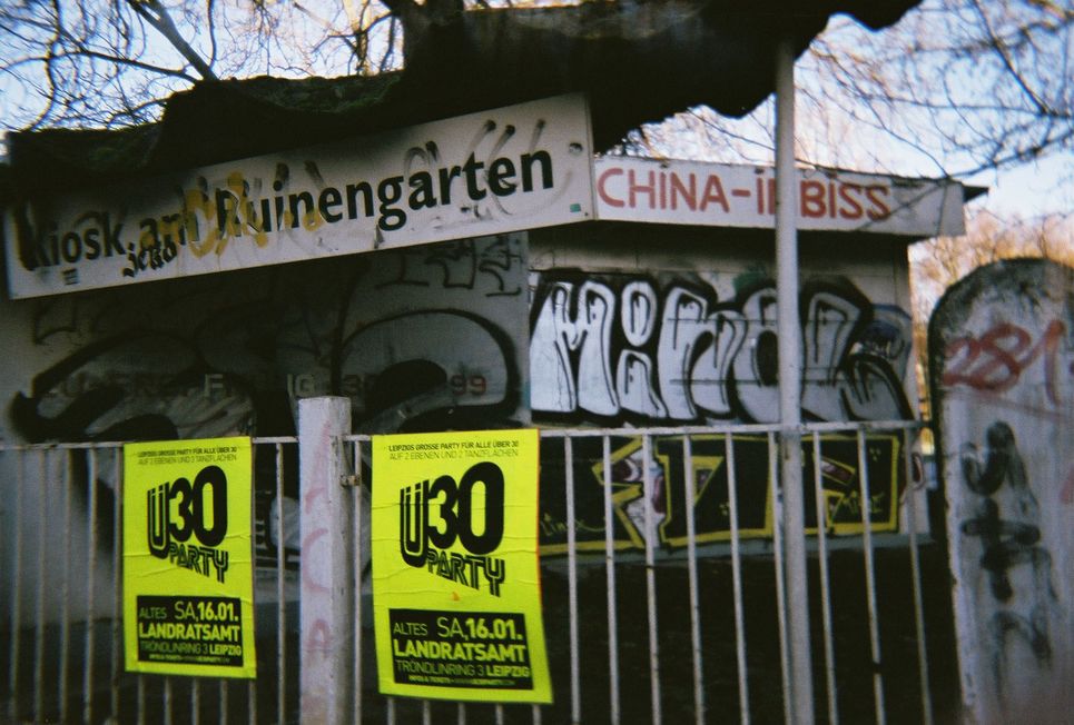 Werbung für Ü-30-Party vor einem heruntergekommenen China-Imbiss.
