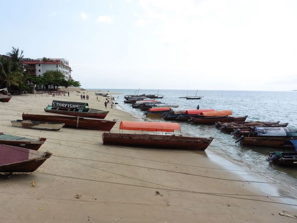 Schmale Boote mit runden Überdachungen am Strand.