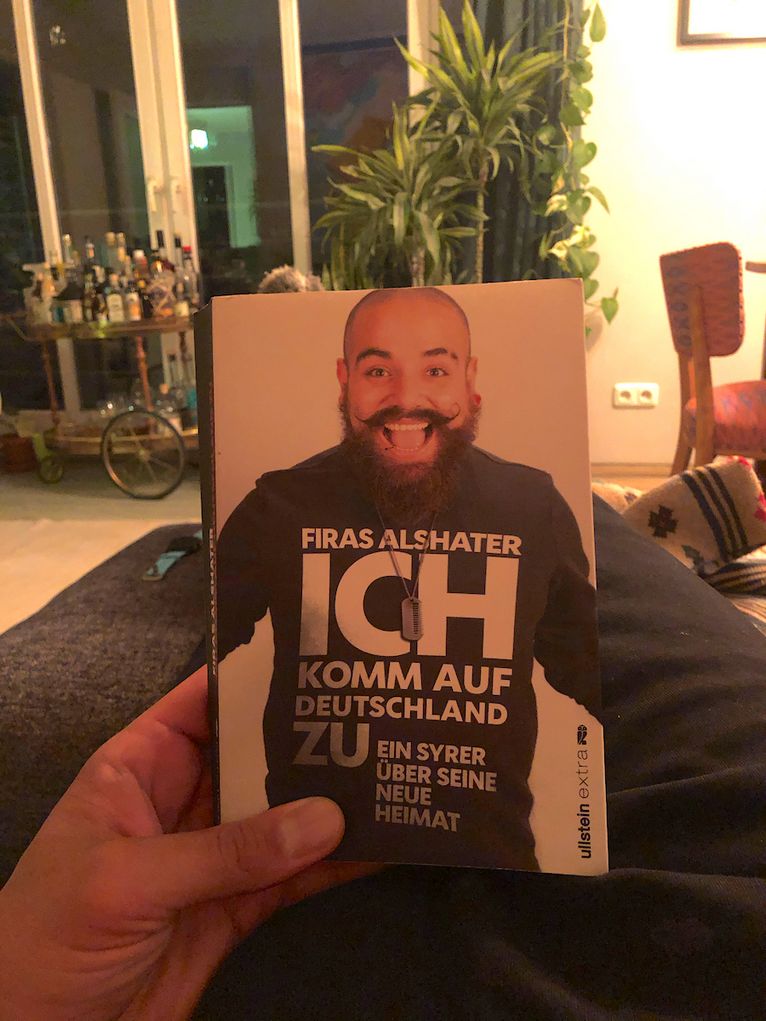 Mit Buch auf dem Sofa.