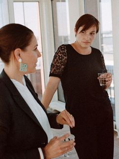 Astrid Irrgang und Nicole Deitelhoff mit Wassergläsern stehend im Gespräch.