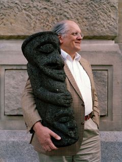 Manfred Krifka mit einer schwarzen Skulptur im Arm, deren Augen geschlossen und deren Hände vor dem Bauch verschränkt sind.