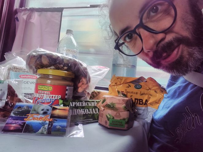 Gianluca Grimalda im Abteil mit viel Proviant und einer Postkarte.
