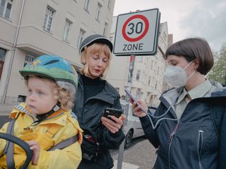 Die Troposphärenforscherin Liina Tõnisson ist mit ihrer kleinen Tochter und unserer Reporterin Amelie Berboth mit dem Fahrrad in Leipzig unterwegs. Sie lesen die Feinstaubbelastung über eine App auf dem Smartphone ab.