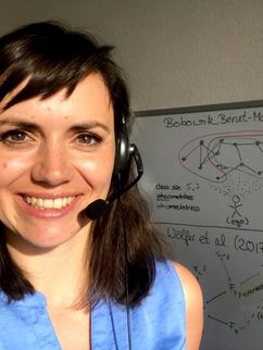 Lydia Recke mit Headset vor einem beschriebenen Whiteboard.