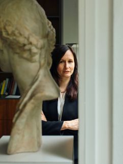 Alexandra W. Busch hinter einer Steinskulptur.