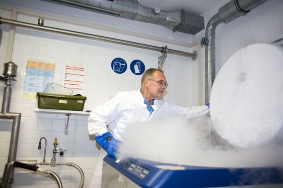 Hans G. Drexler im Labor mit einer dampfenden Maschine.