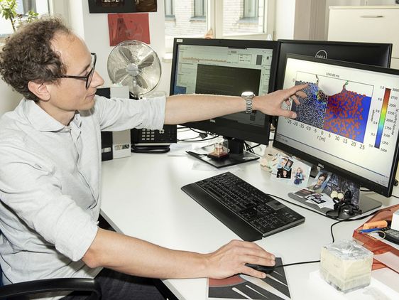 Robert Luther zeigt ein Modell des DART-Einschlags am Computerbildschirm.
