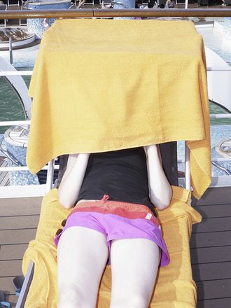 Urlauberin, Gesicht mit Handtuch verdeckt