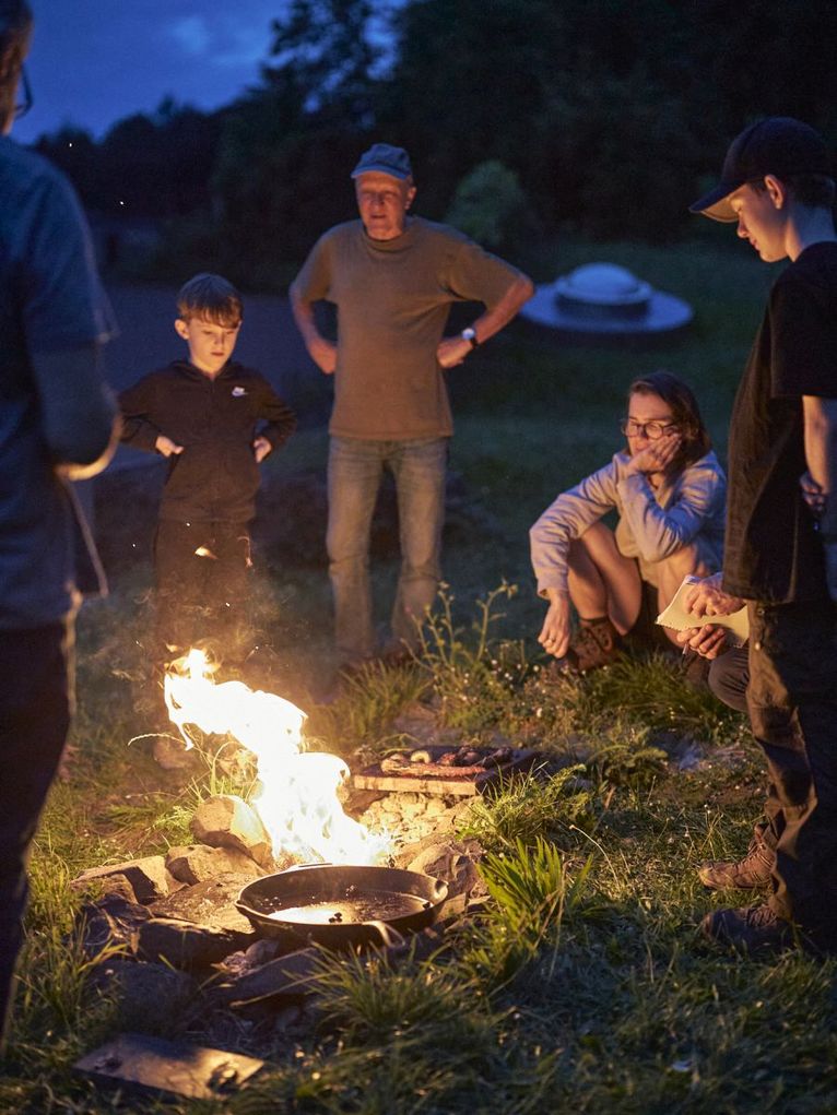 Die Gruppe steht und sitzt Am Lagerfeuer. Leibniz Magazin