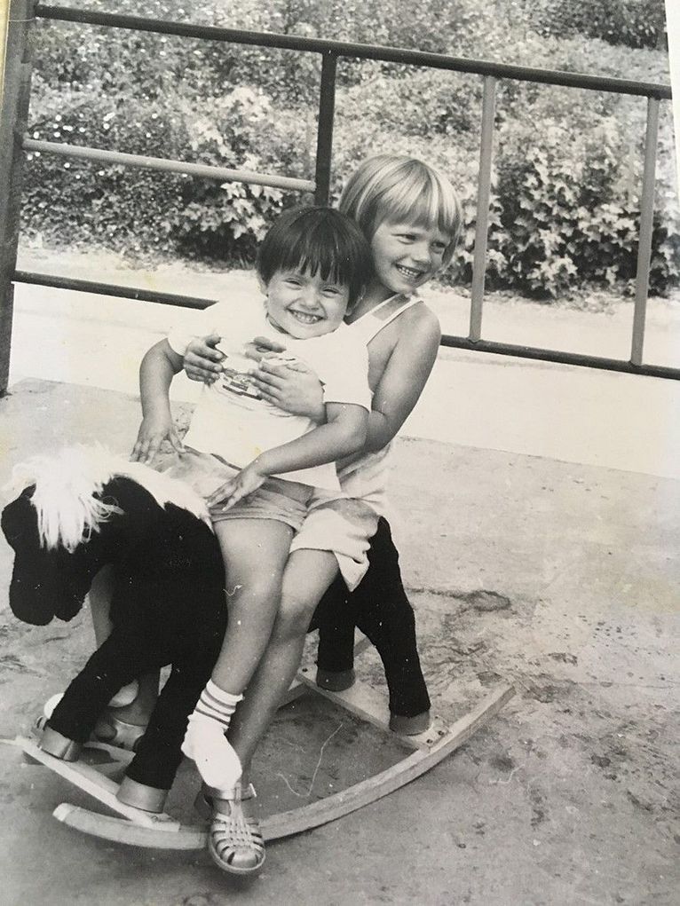Zwei Kinder auf einem Schaukelpferd.