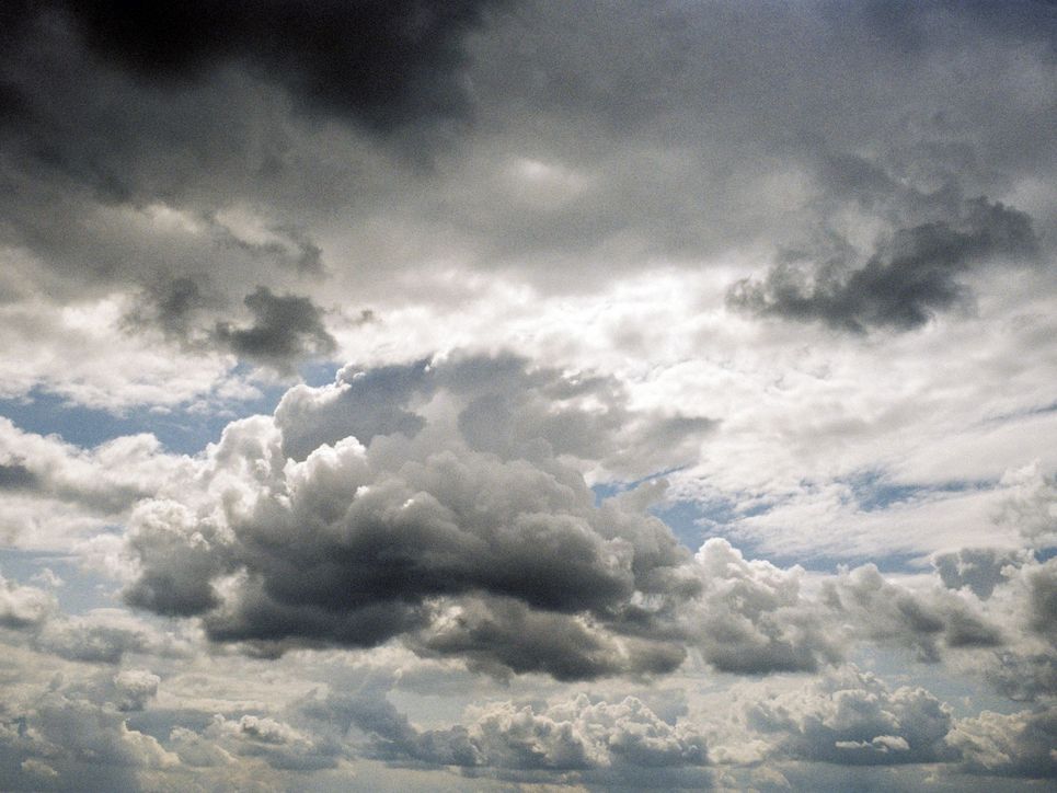 Helle und dunklere Wolken vor blauem Himmel.