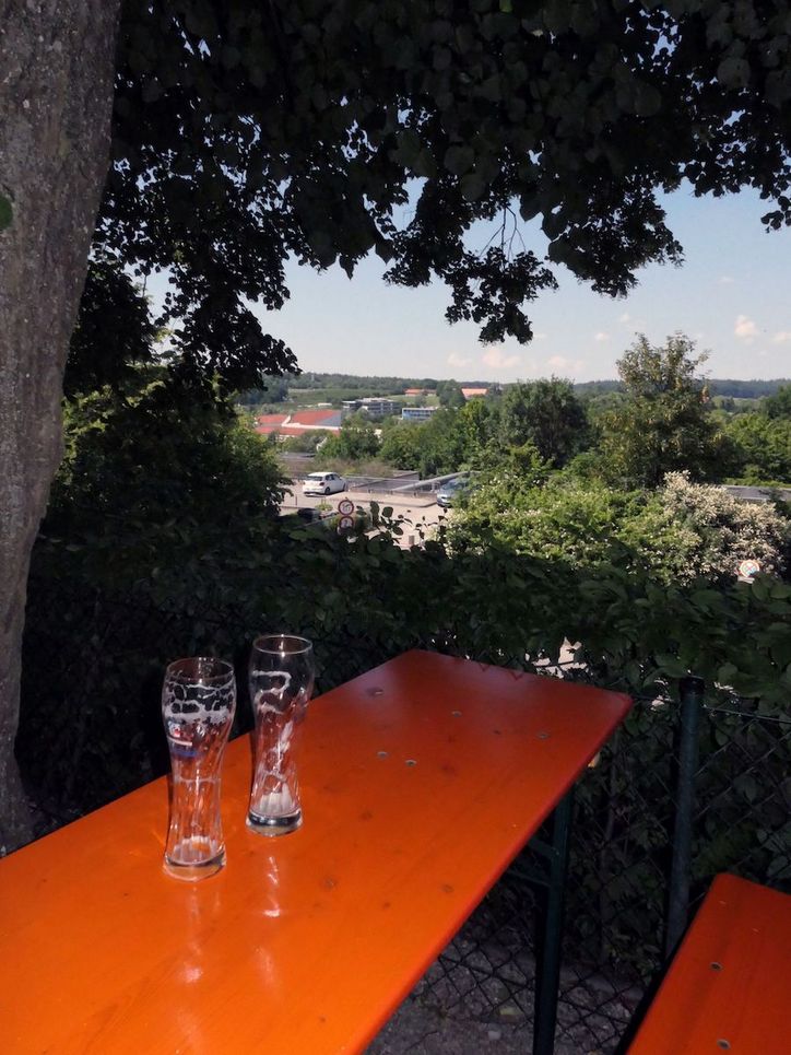 Zwei Leere Biergläser auf einem Biertisch in der Abenddämmerung.