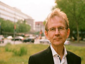 Porträt von Matthias Beller vor einem Plattenbau.