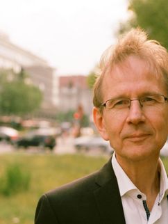 Porträt von Matthias Beller vor einem Plattenbau.