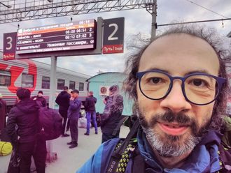 Gianluca Grimalda mit Rucksack in einer belebten Bahnhofshalle.