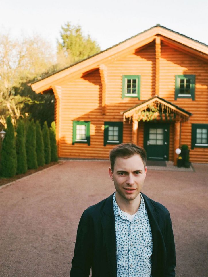 Maik Klotzbach vor einem Blockhaus.