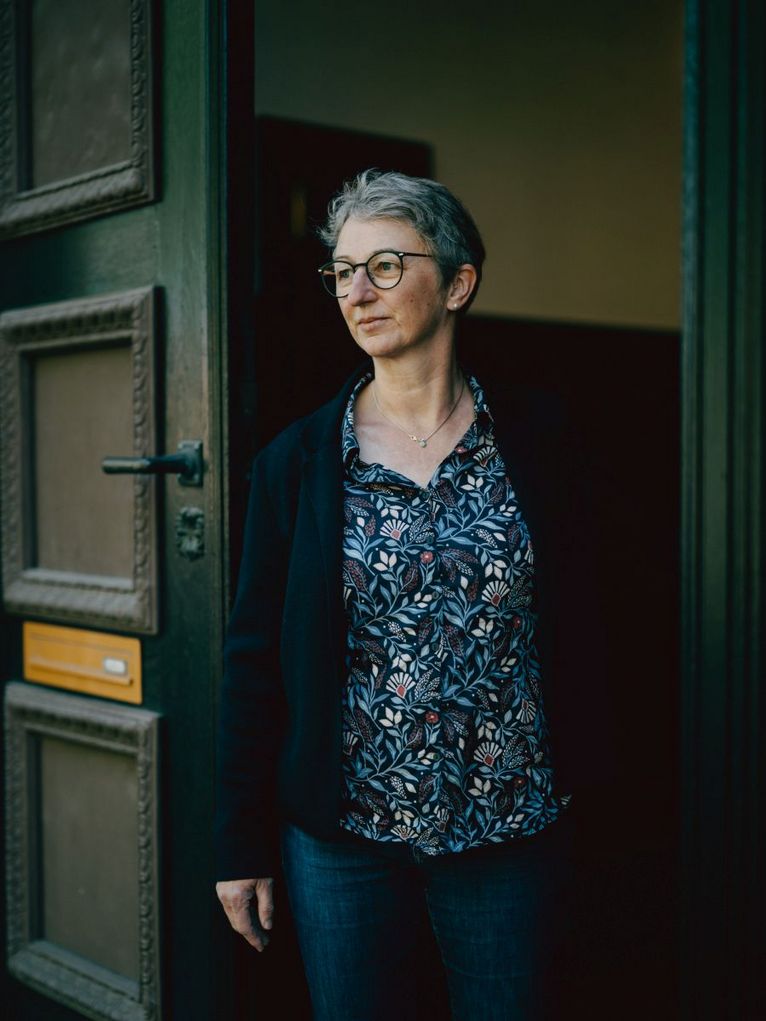 Brigitte Finke läuft aus einer dunkelgrünen Tür raus