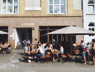 Gäste sitzen im Außenbereich eines Cafés.