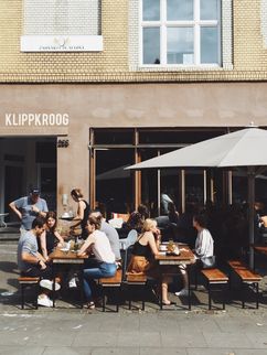 Gäste sitzen im Außenbereich eines Cafés.