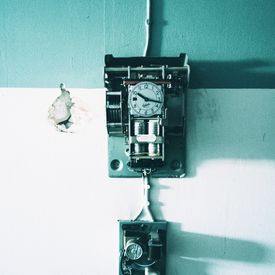 Kasten mit einer kleinen Uhr an der Wand.