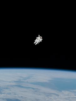 Astronaut schwebt im All über der Mondoberfläche.