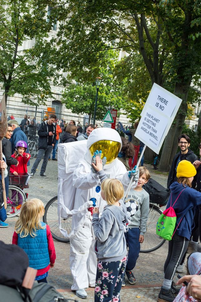 Kinder und ein verkleideter Astronaut.