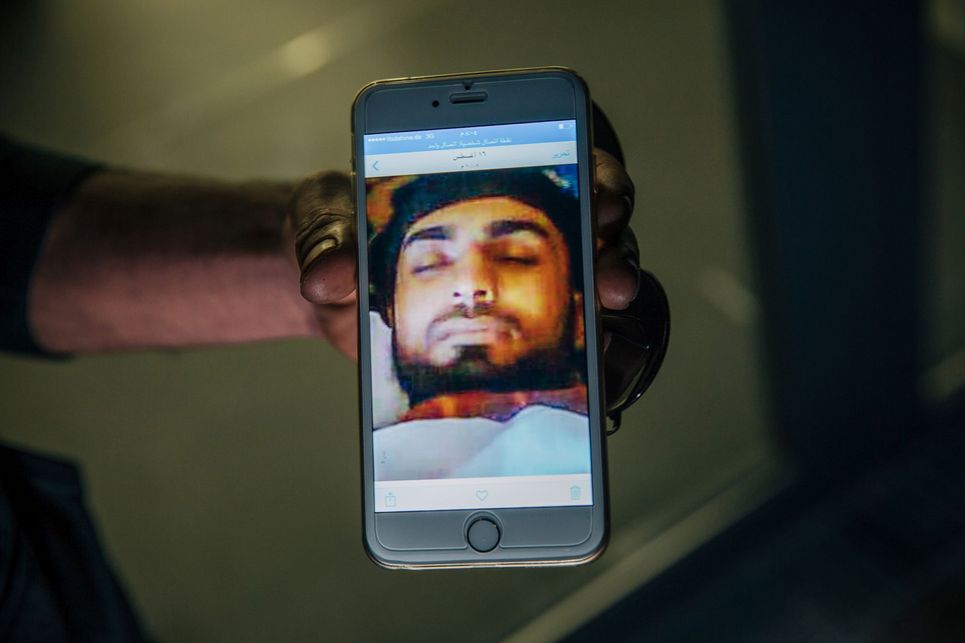 Foto auf einem Handydisplay von einem Mann mit geschlossenen Augen.