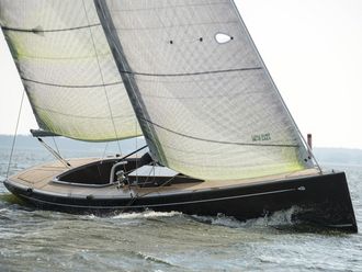 Segelboot bei leichtem Wellengang, es liegt leicht geneigt im Wasser.