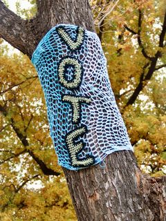 Strickschal an einem Baum mit Aufschrift "Vote"