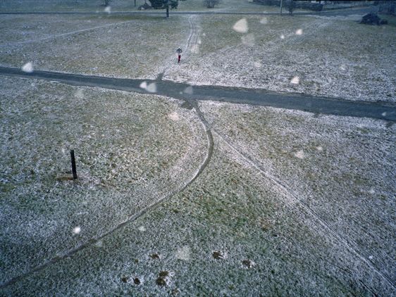 Weggabelung im leichten Schnee mit einem Jogger.