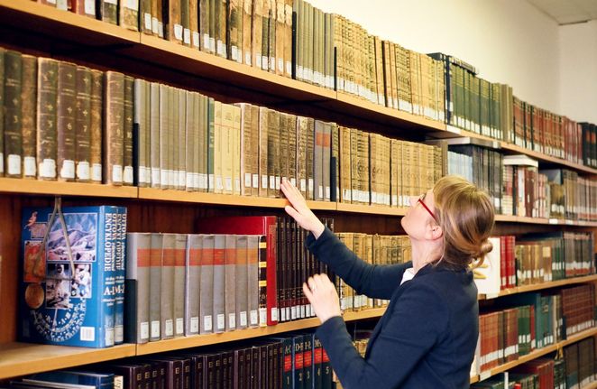 Ksenia Stanicka-Brzezicki vor einem Bücherregal.