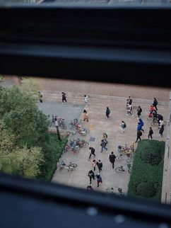 Blick von oben auf Personen vor einem Gebäude