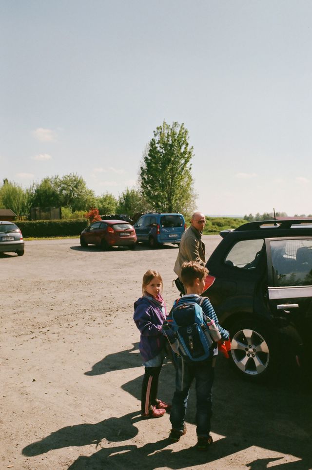 Der Vater mit Kuba und Ida auf einem Parkplatz