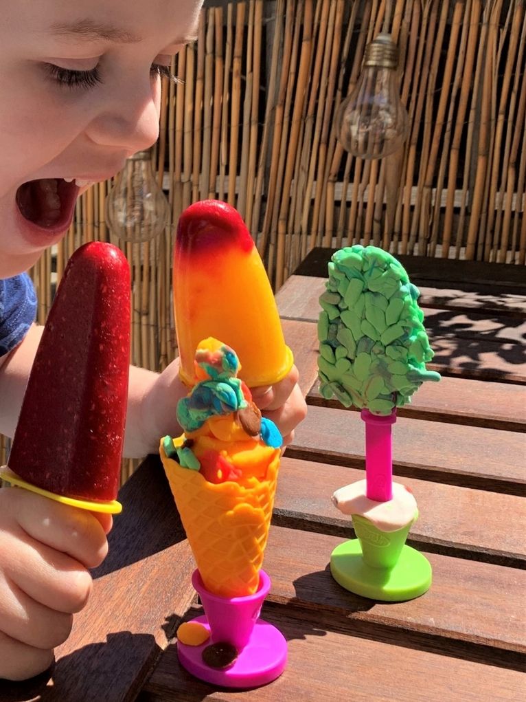 Ein Kind mit buntem, selbstgemachtem Eis.