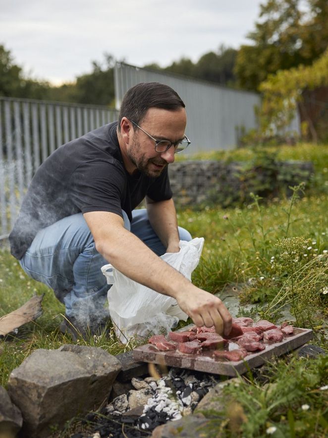 Ein Mann legt Fleisch auf die Steinplatte. Leibniz Magazin