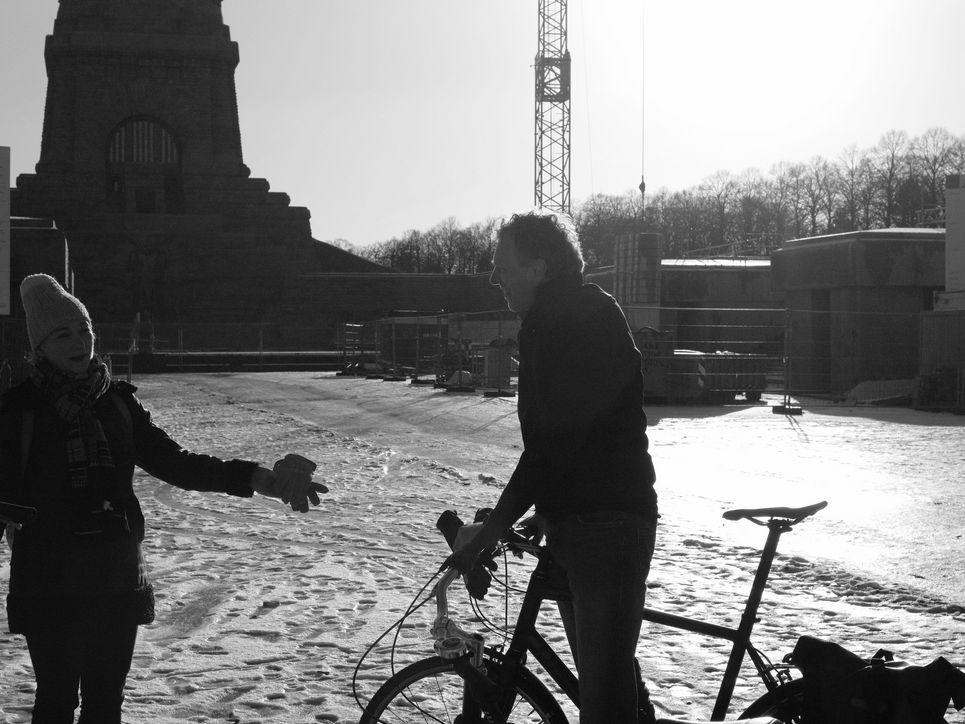Rosa Loy und Sebastian Lentz mit seinem Fahrrad vor einer Baustelle beim Völkerschlachtdenkmal.