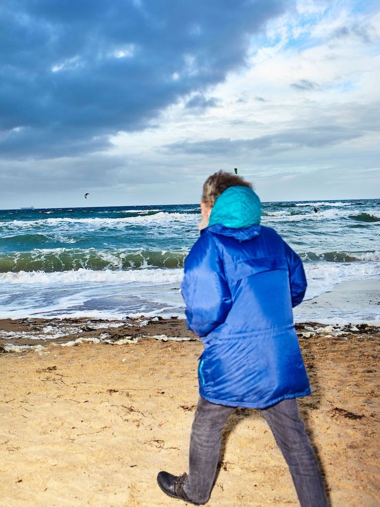 Der Ostseeforscher geht beherzten Schrittes am Strand spazieren.