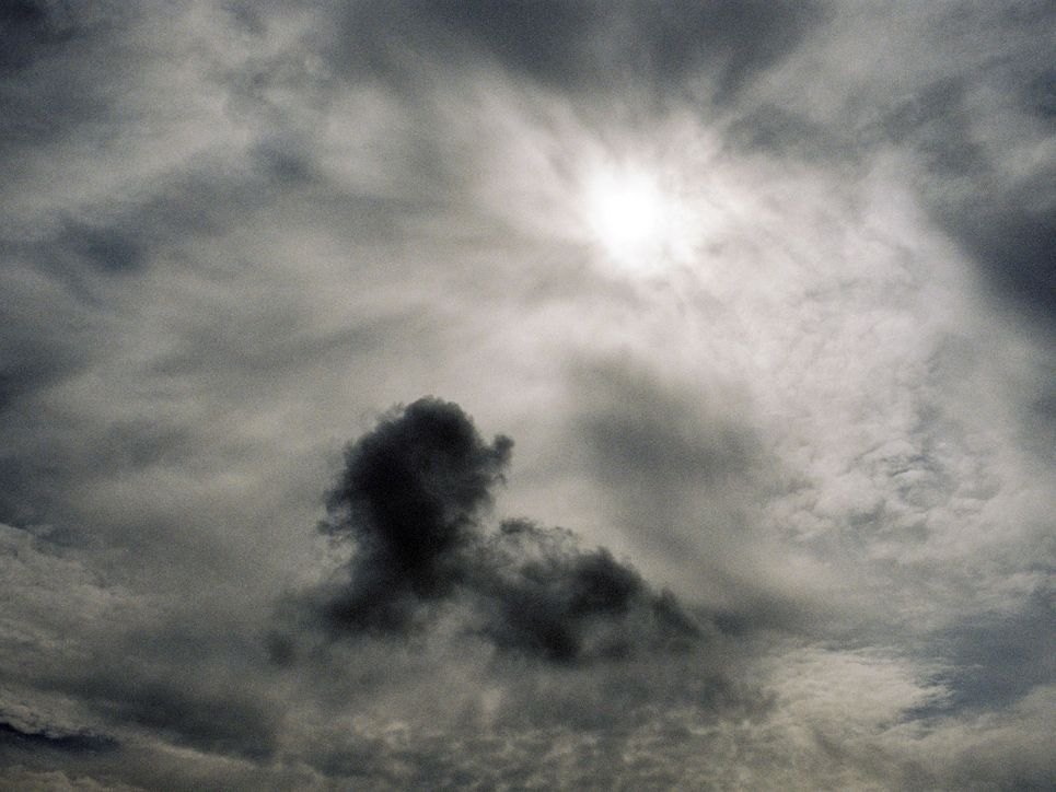 Erleuchtete Wolken und eine dunkle Wolke im Vordergrund.