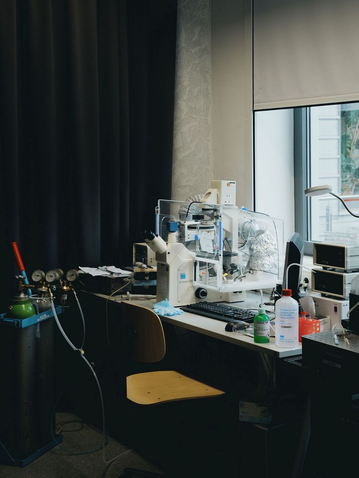Viele Gerätschaften auf einem Labortisch mit Stuhl davor.