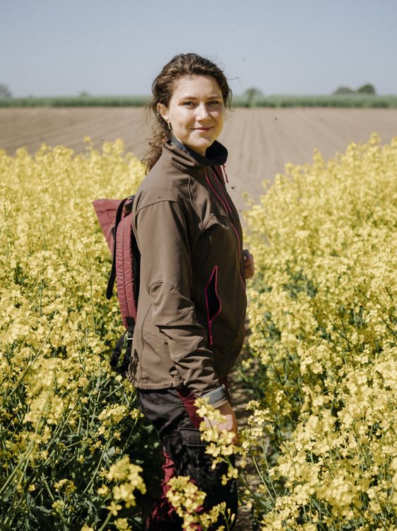 Kathrin Grahmann steht inmitten eines blühenden Rapsfeldes.