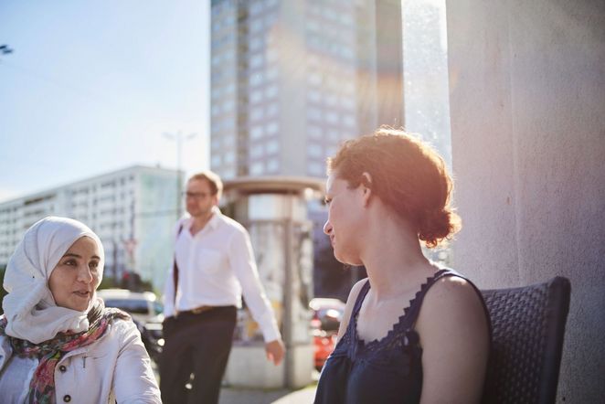 Hala und Marwa in der Stadt, hinter ihnen Hochhäuser.