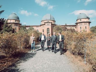 Fünf Personen vor dem Gebäude des Potsdam-Instituts für Klimafolgenforschung.