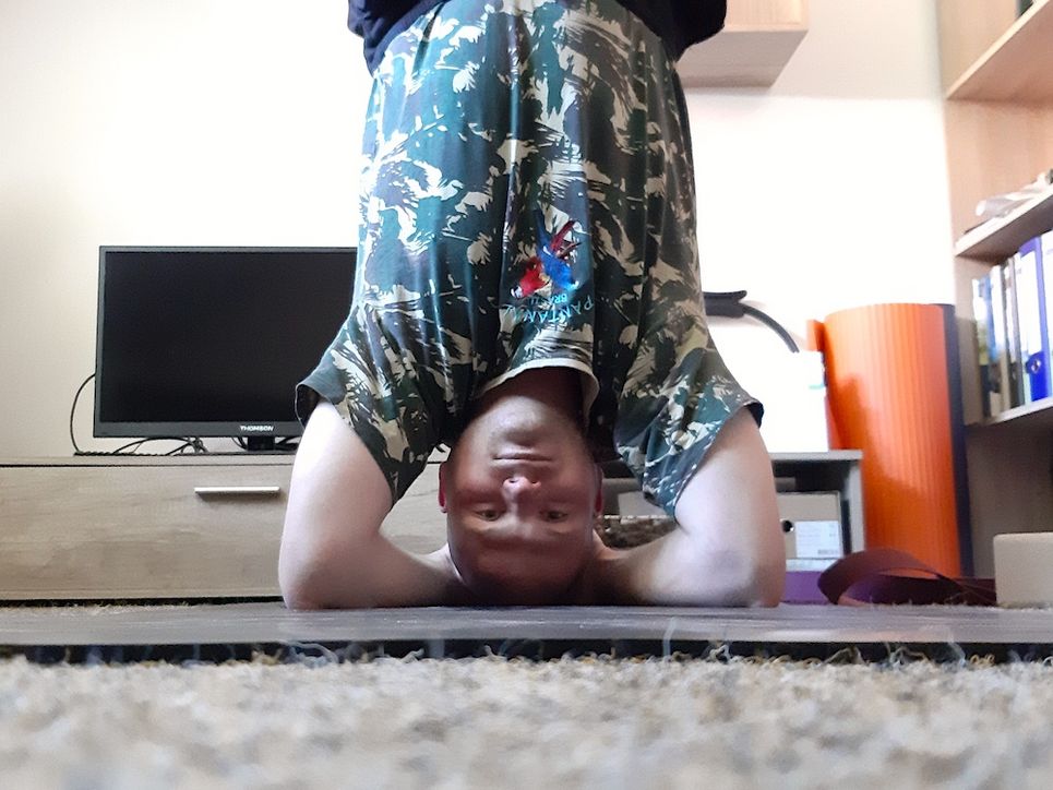 Patrick Marcineck Kopfüber in seinem Büro in Yoga-Pose.