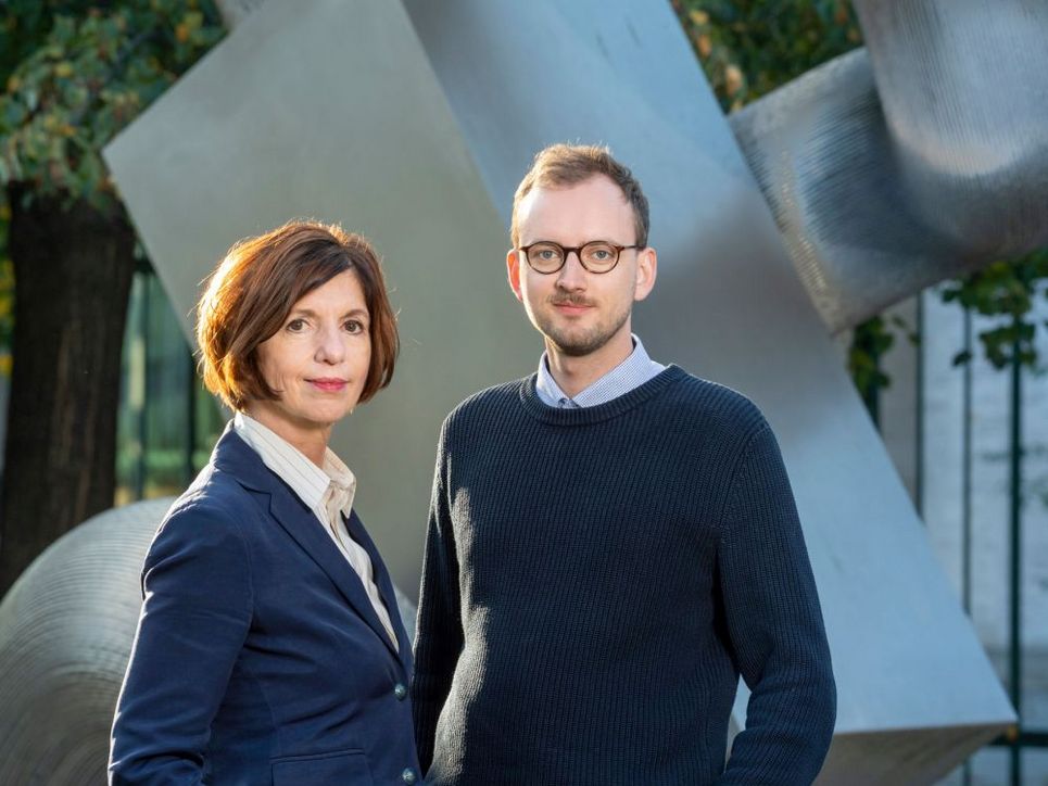 Jutta Allmendinger und Jan Wetzel vor einer Metall-Skulptur.
