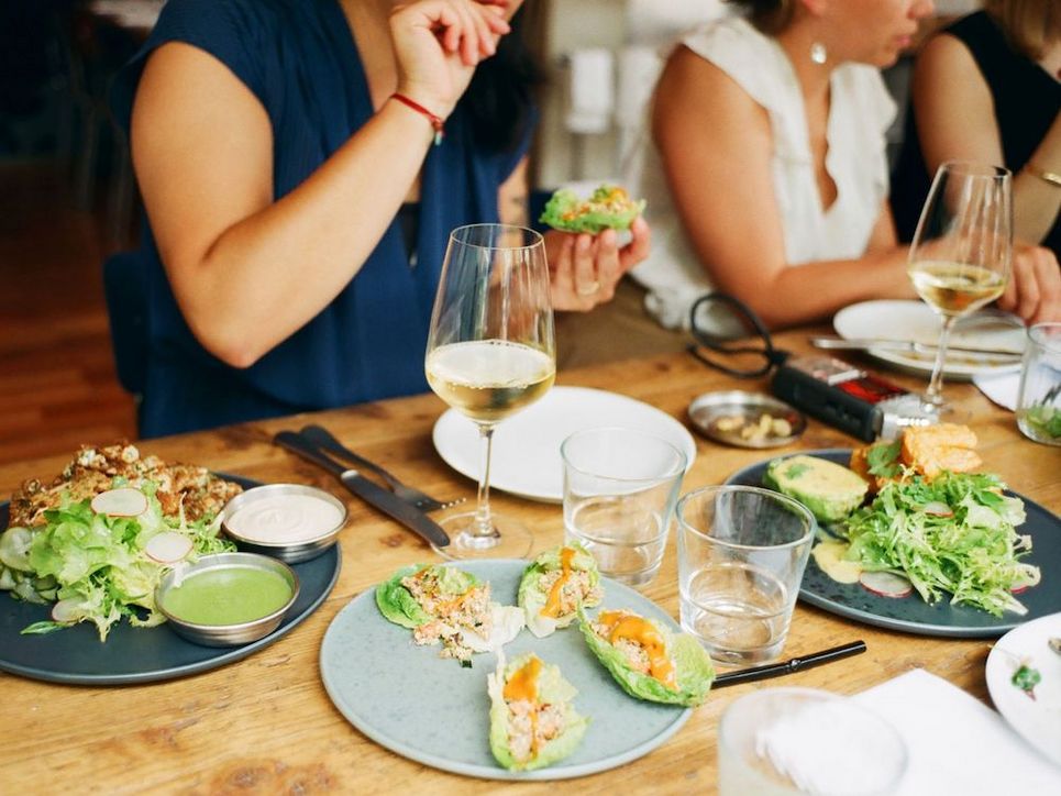 Personen beim Essen und Weintrinken.