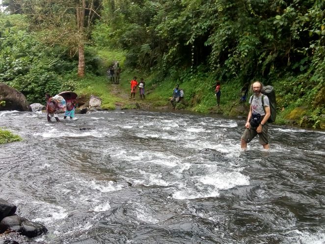 Gianluca Grimalda steht kniehoch in einem Fluss.
