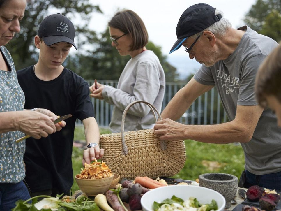 Die Gruppe bereitet zusammen das Essen vor. Auf dem Tisch liegt das gesammelte Essen. Leibniz Magazin