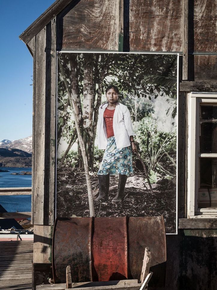 Bild einer jungen Frau, die Angehörige der Inuit ist, an einer Veranda am Meer angebracht.